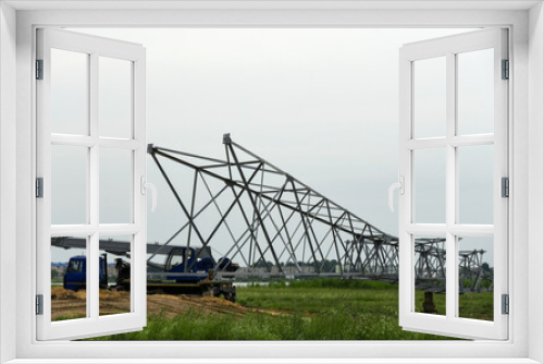 Fototapeta Naklejka Na Ścianę Okno 3D - Builders install power line tower