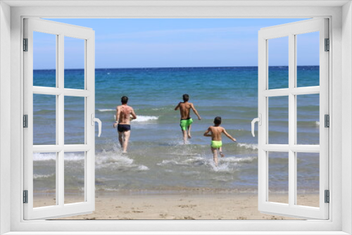 Fototapeta Naklejka Na Ścianę Okno 3D - Tata i synowie podczas wygłupów na plaży. Dad and sons on the beach.