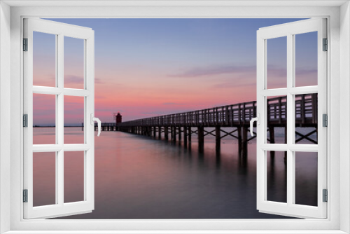 Fototapeta Naklejka Na Ścianę Okno 3D - Alba al faro rosso di Lignano, paesaggio sul mare con passeggiata pedonale.