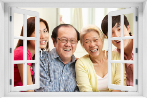 Portrait Of Chinese Parents With Adult Children Relaxing At Home