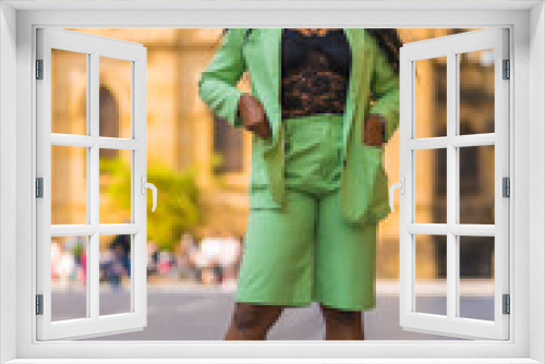 Lifestyle of a young girl of black African ethnicity with a beautiful green suit. Sightseeing in the city