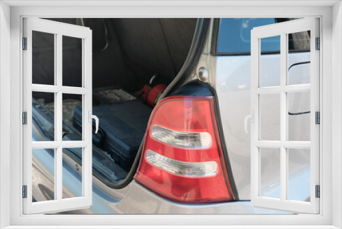 Fototapeta Naklejka Na Ścianę Okno 3D - taillight of a silver hatchback car and open trunk with repair tool box. summer travel and car jorney concept