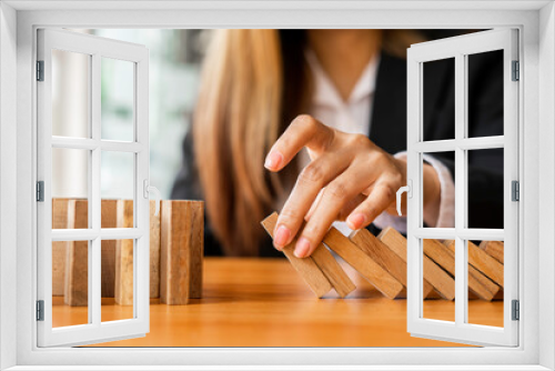 Fototapeta Naklejka Na Ścianę Okno 3D - A businesswoman blocks a falling wooden block like a domino. It is like stopping business risks with a strategy. and project management the best of the business