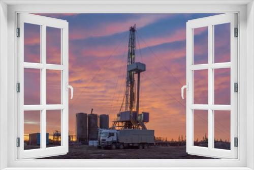 Fototapeta Naklejka Na Ścianę Okno 3D - Drilling of deep well at the oil and gas field. In the foreground, cementing unit and cement bins. Compound cementing well. Beautiful northern sunset