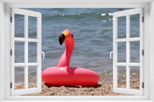 Fototapeta Naklejka Na Ścianę Okno 3D - Inflatable circle in the shape of pink flamingo on a sandy beach. Summer leisure, sea vacation