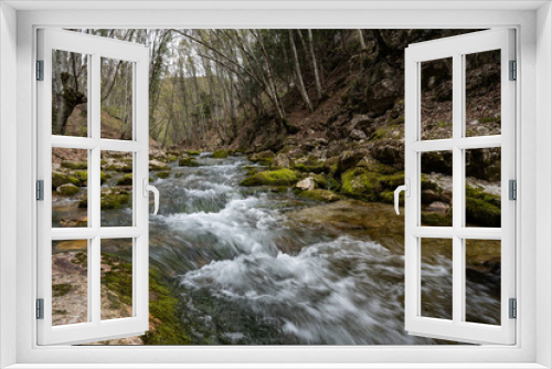 Fototapeta Naklejka Na Ścianę Okno 3D - Stormy river in the forest. The mountain river flows among the boulders. Strong current.