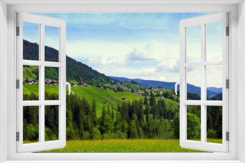 Fototapeta Naklejka Na Ścianę Okno 3D - Aussicht im Kleinwalsertal auf Dorf Mittelberg umrahmt von grünen Wiesen und Wald unter blauem Himmel
