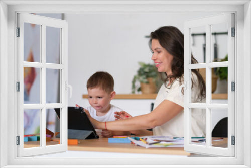 Mother with young boy using digital tablet.happy mom and baby play educational online games on the tablet.