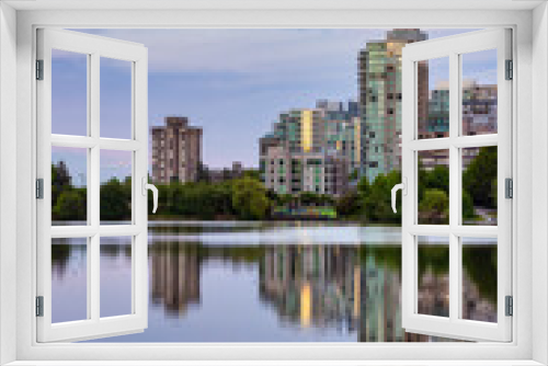 Fototapeta Naklejka Na Ścianę Okno 3D - View of Lost Lagoon in famous Stanley Park in a modern city with buildings skyline in background. Colorful Sunset Sky. Downtown Vancouver, British Columbia, Canada.