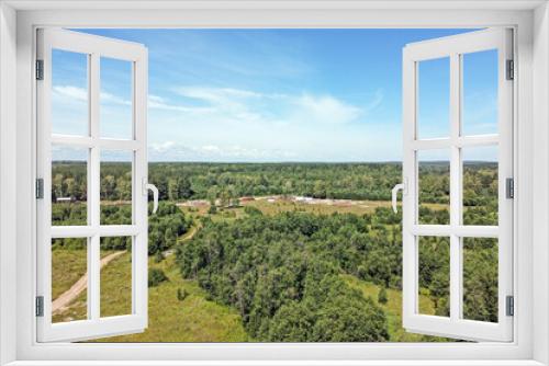 Fototapeta Naklejka Na Ścianę Okno 3D - Top view of industrial facilities in the forest against a blue sky with white clouds