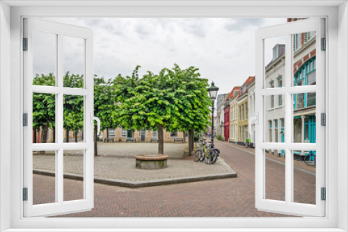 Fototapeta Naklejka Na Ścianę Okno 3D - Vlissingen, The Netherlands, July 24, 2021: tree-lined little square and street with colorful facades in the old town