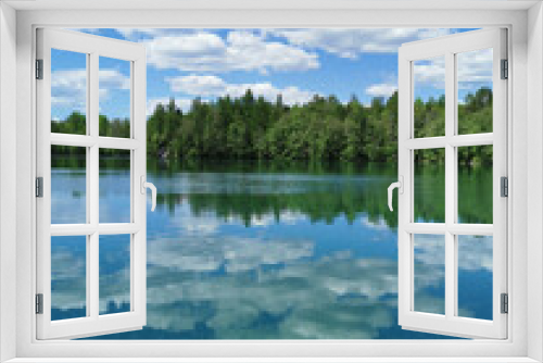 Fototapeta Naklejka Na Ścianę Okno 3D - The shore of the lake is bright with clear water, in which you can see the marble on the bottom and reflect the sky with clouds, in the mountain park Ruskeala.