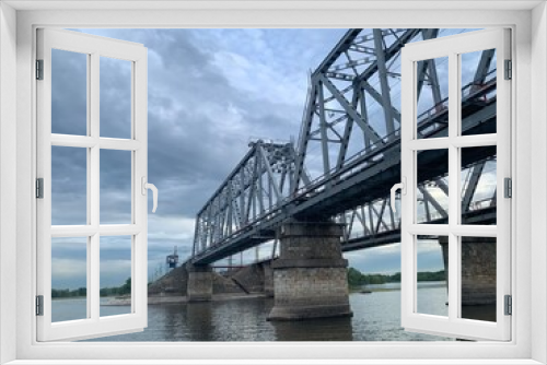 Fototapeta Naklejka Na Ścianę Okno 3D - The gray Samara railway bridge over the surface of the Samara river; photo from the river