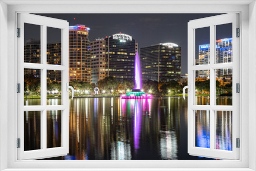 Fototapeta Naklejka Na Ścianę Okno 3D - Night time panoramic photo in downtown Orlando of Lake Eola with the fountain lit up and colorful reflections in the water