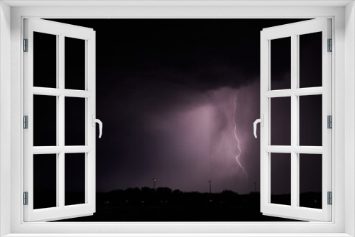 Fototapeta Naklejka Na Ścianę Okno 3D - Gewitter. Blitz in der Nacht erhellt Wolken, Silhouette einer Stadt hebt sich ab.
