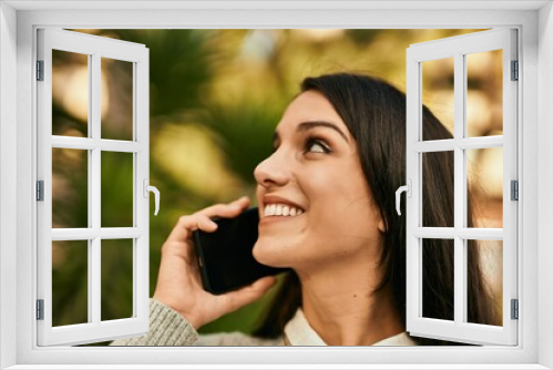 Young hispanic woman smiling happy talking on the smartphone at the city.