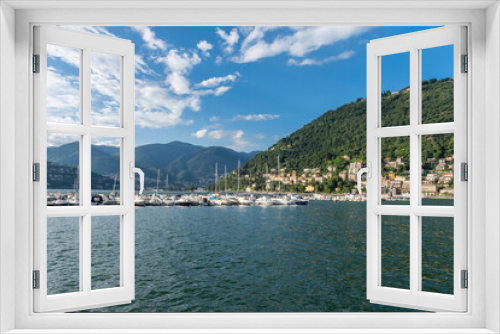 Fototapeta Naklejka Na Ścianę Okno 3D - View over the beautiful, gorgeous lake Como and the marina seen from the town of Como. It is a beautiful sunny summer day, with blue sky and a few clouds. There are many boats and dinghy in the marina
