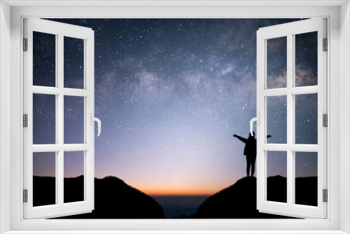 Fototapeta Naklejka Na Ścianę Okno 3D - Silhouette of young female traveler and backpacker watched the star and milky way alone on top of the mountain. She raised both hands, showing enjoyed traveling and was successful.