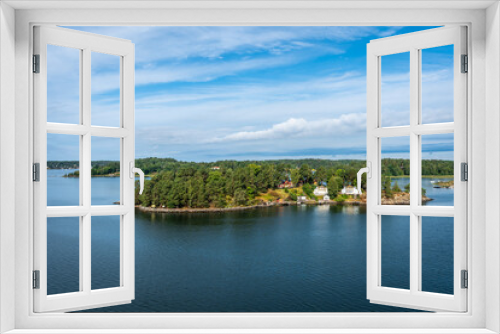 Fototapeta Naklejka Na Ścianę Okno 3D - Amazing panoramic view of beautiful evergreens small islands and rocky coast of Scandinavia on summer day. Shot from cruise ship. Skyline. Forest green long coastline. Water voyage to Sweden Stockholm