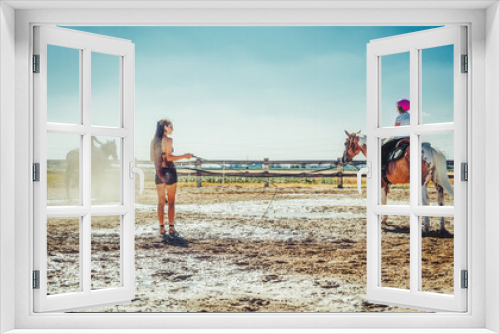 Fototapeta Naklejka Na Ścianę Okno 3D - girl trains horse on a beautiful summer day.