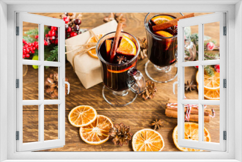 Fototapeta Naklejka Na Ścianę Okno 3D - Christmas mulled red wine with spices and oranges on a wooden rustic table. Traditional hot drink at Christmas with gifts