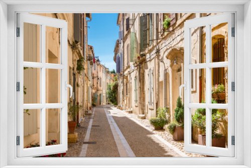 Fototapeta Naklejka Na Ścianę Okno 3D - View of an idyllic street with green plants in Arles. 