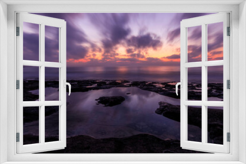 Fototapeta Naklejka Na Ścianę Okno 3D - amazing scenic view at a sea shore from a coast after dramatic colorful sunset with flying blured clouds and reflection on water surface , beautiful ocean landscape