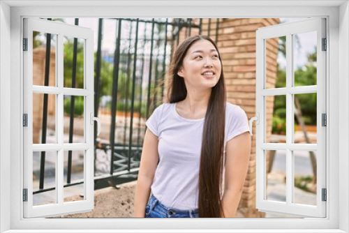 Young chinese girl smiling happy standing at the city.