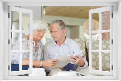 Couple examining blueprints on sofa