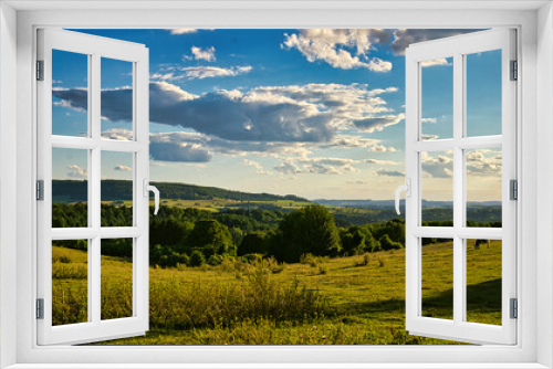 Fototapeta Naklejka Na Ścianę Okno 3D - A sunny day in Saarland with a view over meadows into the valley. Some sunny clouds in the sky and cows grazing. A moment to linger, rest and enjoy nature