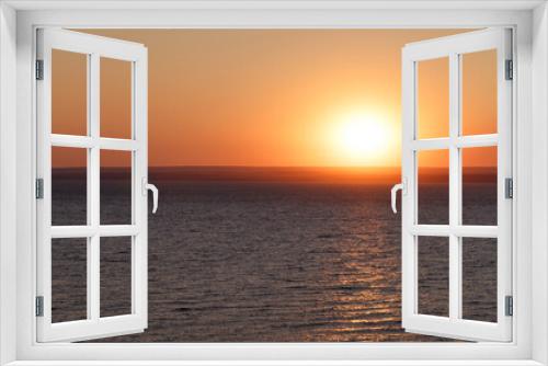Fototapeta Naklejka Na Ścianę Okno 3D - Beautiful colorful sunset over the sea. The red sun and the absence of clouds. Sea horizon. Aerial view. Landscape. The concept of a postcard picture. Light waves on the sea surface