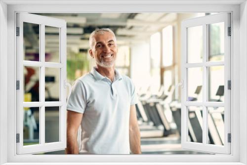 Portrait of happy mature athlete during sports training at gym.