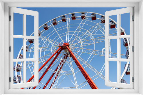 Fototapeta Naklejka Na Ścianę Okno 3D - Ferris wheel turns on a sunny day at amusement park. No people