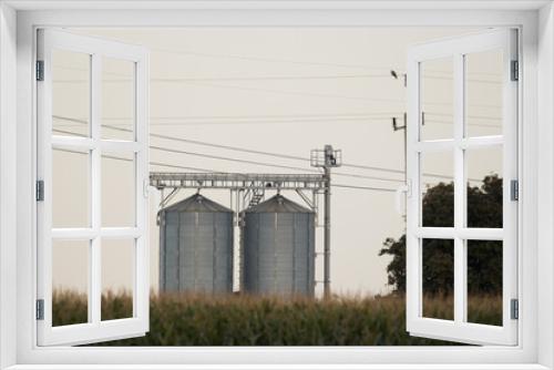 Fototapeta Naklejka Na Ścianę Okno 3D - Corn field with silos in the background