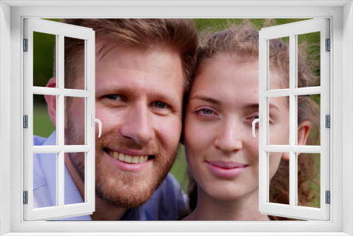 Bokeh close up portrait of happy young couple looking at camera outdoors