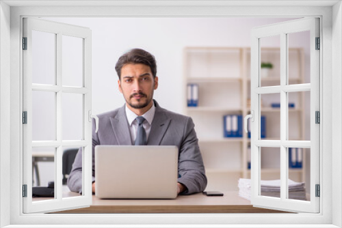 Young male employee and too much work in the office