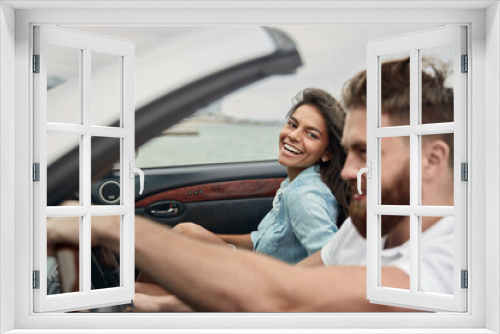 Young european couple riding in cabriolet car