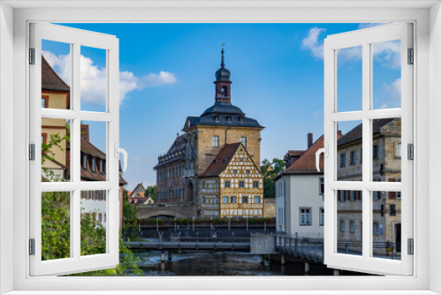 Fototapeta Naklejka Na Ścianę Okno 3D - Altes Rathaus in Bamberg im Hintergrund mit Regnitz am Morgen bei blauem Himmel von der Bischofsmühlbrücke