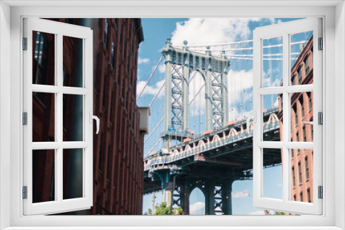 Fototapeta Naklejka Na Ścianę Okno 3D - Brooklyn bridge framed by buildings in Dumbo.
