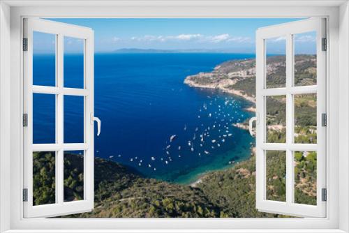 Fototapeta Naklejka Na Ścianę Okno 3D - View from above, stunning aerial view of a bay with boats and luxury yachts sailing on a turquoise, clear water surrounded by cliffs. Porto Santo Stefano, Monte Argentario, Italy.