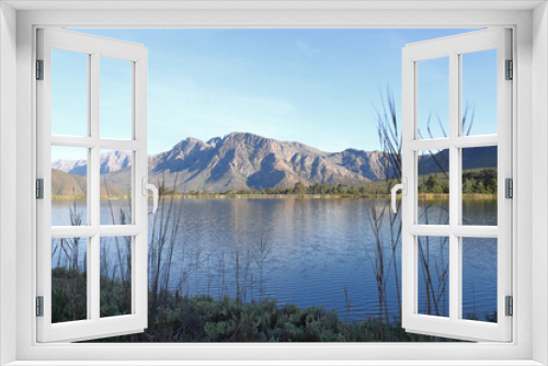 Fototapeta Naklejka Na Ścianę Okno 3D - A scenic view across a dam towards mountains