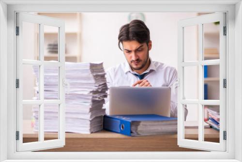 Young businessman employee unhappy with excessive work in the office