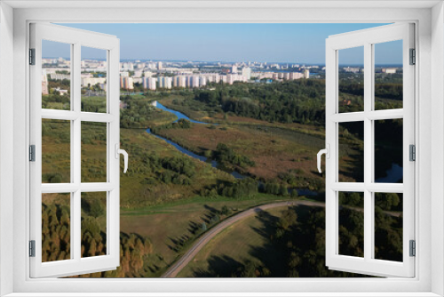 Fototapeta Naklejka Na Ścianę Okno 3D - City landscape. Nearby there is a park area. Blue sky with white clouds. Aerial photography.