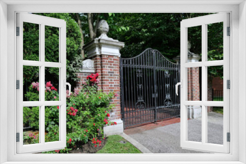 Fototapeta Naklejka Na Ścianę Okno 3D - Closed gate of gated home or mansion, with climbing rose bushes