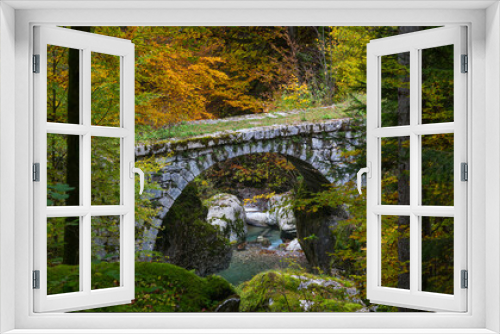 Fototapeta Naklejka Na Ścianę Okno 3D - old stone bridge over a river in forest with autumn colors