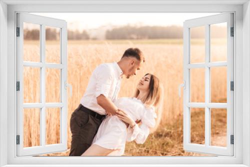 A young couple man and woman hug with tenderness in nature in the summer. Lovers