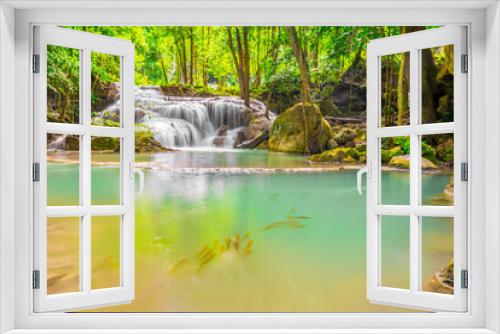 Fototapeta Naklejka Na Ścianę Okno 3D - Waterfalls and fish swim in the emerald blue water in Erawan National Park. Erawan Waterfall is a beautiful natural rock waterfall in Kanchanaburi, Thailand.Onsen atmosphere. 