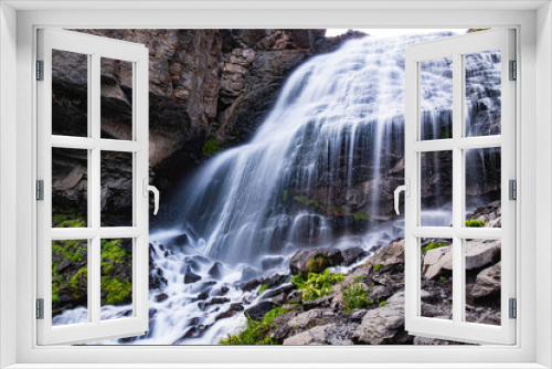 Fototapeta Naklejka Na Ścianę Okno 3D - A fantastic mountain waterfall, the stormy streams of a mountain river fall from a great height on the rocks on a sunny day