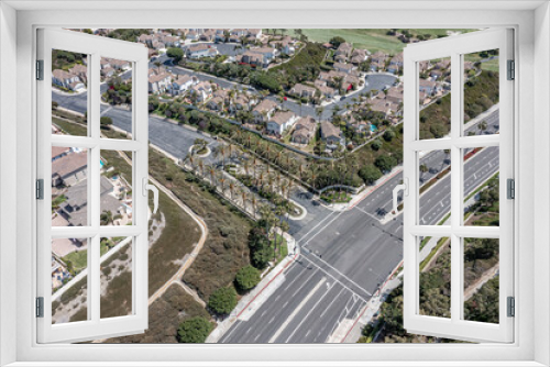 Fototapeta Naklejka Na Ścianę Okno 3D - Gated entry to an upscale California neighborhood, aerial view of street lined with palm trees.
