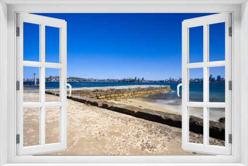 Fototapeta Naklejka Na Ścianę Okno 3D - Sunny Spring day on Sydney Harbour with nice rocks in the foreground the soft waves crashing on the shore and the beautiful harbour foreshore as a backdrop NSW Australia
